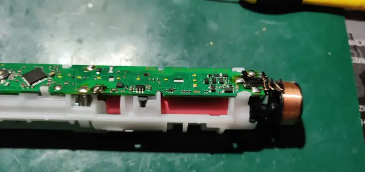 Rozłożona szczoteczka Oral-B z widoczną płytką drukowaną i bateriami. Czy można wymienić baterię w szczoteczce Oral-B? Tak, jest to możliwe.