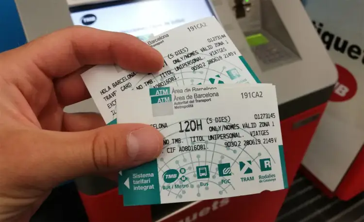 Dłoń trzyma bilety na komunikację miejską w Barcelonie. Na biletach widnieje napis "Hola Barcelona Travel Card" oraz informacje o ważności.