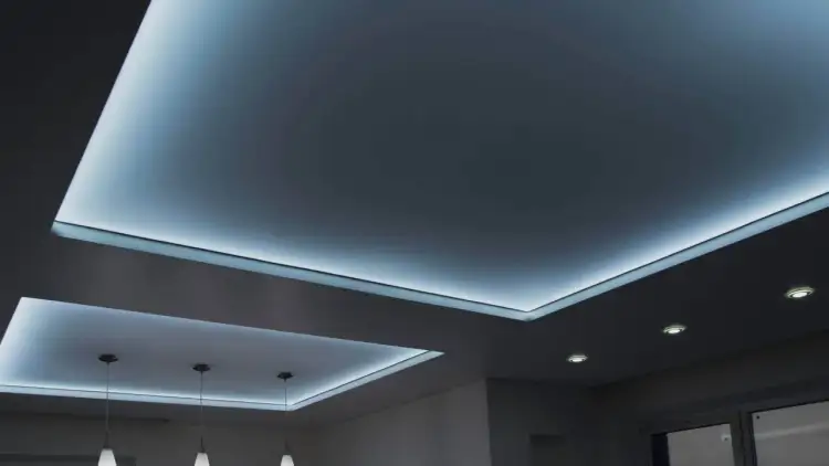Nowoczesny sufit napinany z subtelnym, niebieskim podświetleniem tworzy atmosferę relaksu.