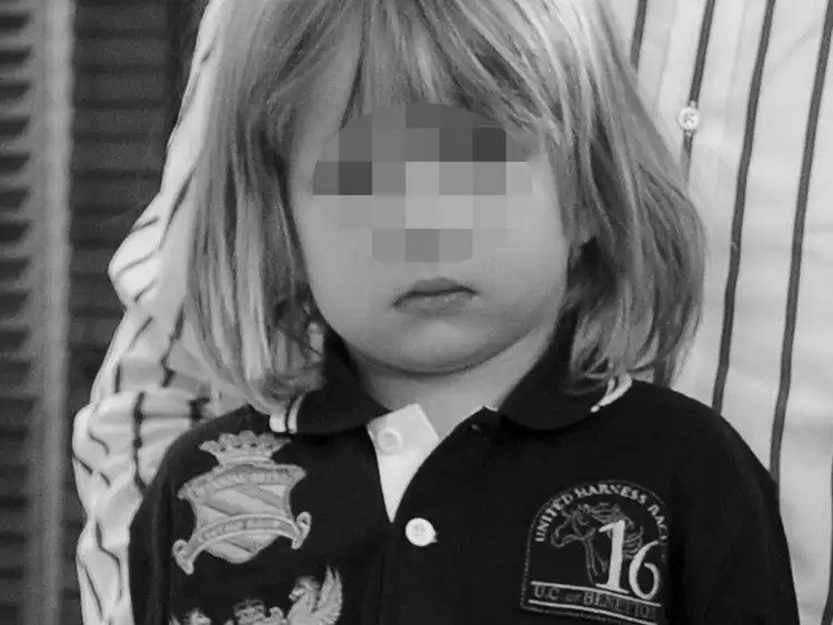 Mały Maks Chajzer w czarnej koszulce z herbem i napisem "UNITED HARNESS RACING 16 UC of BENETTON". Obok widać fragment ubrania Filipa Chajzera.