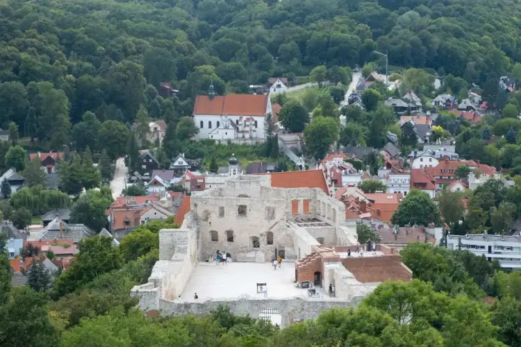 Ruiny zamku w Kazimierzu Dolnym, idealne miejsce, by zobaczyć, co zwiedzić w okolicy. W tle malownicze miasteczko i las.
