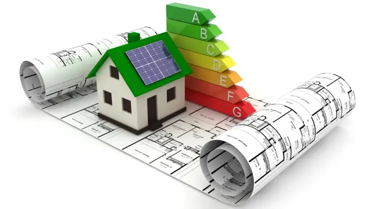 Model domu z panelami słonecznymi na tle planów i skali energetycznej.