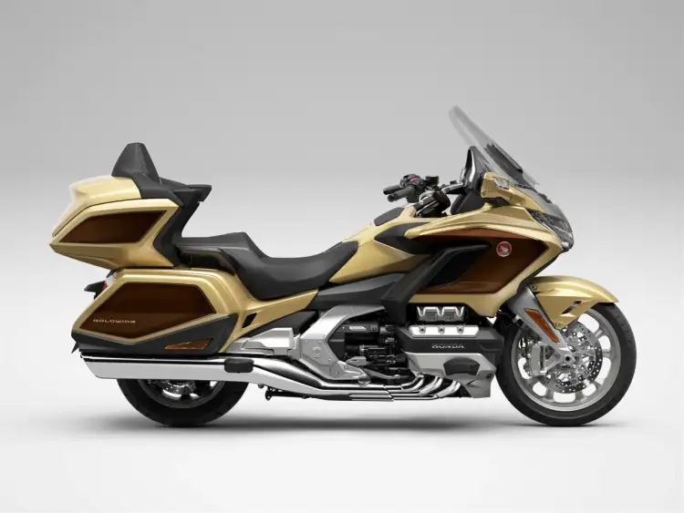 Złoty motocykl Honda Goldwing z brązowymi akcentami, gotowy na dalekie podróże.