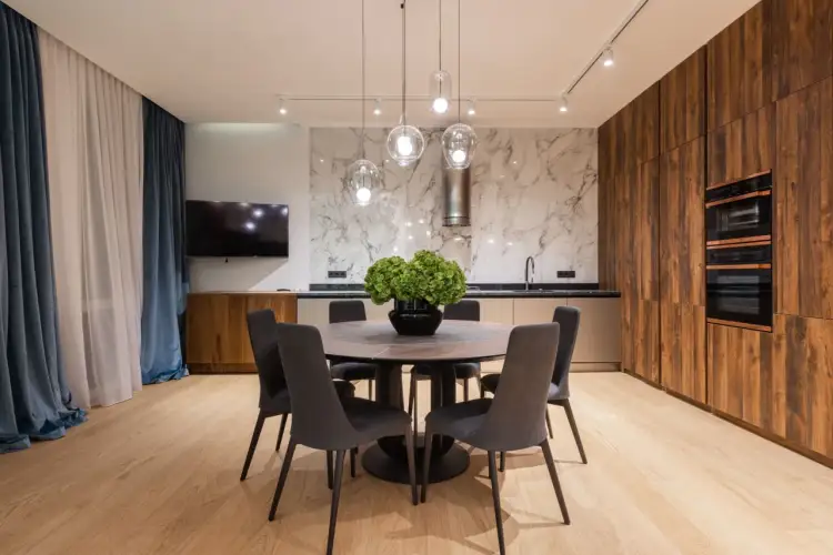 Nowoczesne wykończenie mieszkania pod klucz w Warszawie. Elegancka jadalnia z okrągłym stołem i designerskimi lampami.
