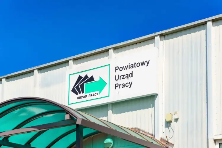 Znak "Powiatowy Urząd Pracy" nad zielonym zadaszeniem. Czy szukanie pracy przez urząd pracy to realna szansa dla specjalistów?