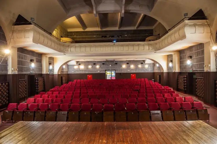 Puste czerwone fotele w kinie Roma czekają na widzów. Sprawdź repertuar i zarezerwuj miejsce!