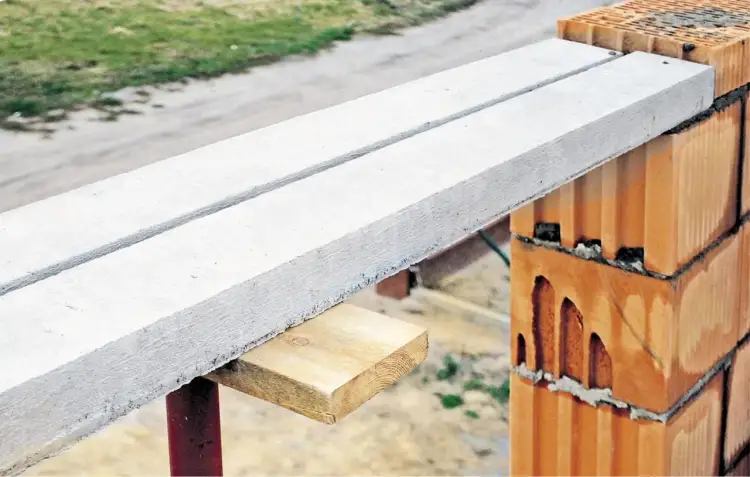 Dwa gotowe nadproża betonowe, idealnie dopasowane wymiarami, czekają na montaż na ścianie z pustaków ceramicznych.