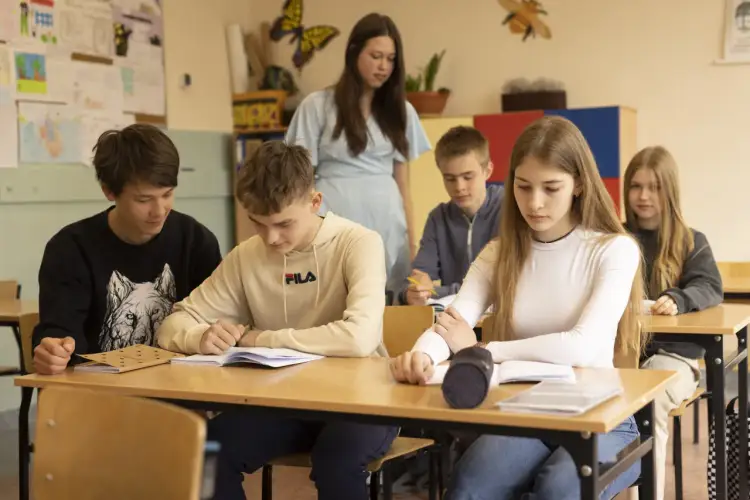 Uczniowie w klasie skupieni na nauce, przygotowują się do egzaminów, by wiedzieć, jak obliczyć punkty do liceum.
