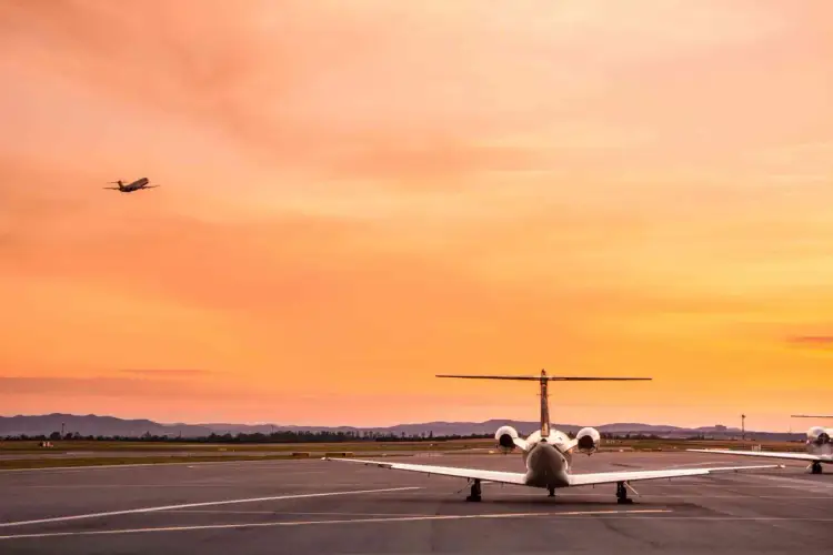 Samolot na pasie startowym o zachodzie słońca. Czy czarter to szybki sposób na podróż?