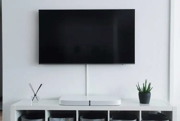 Minimalistyczny salon z telewizorem wiszącym na ścianie. Idealna wysokość, by wygodnie oglądać filmy, to klucz do komfortu.