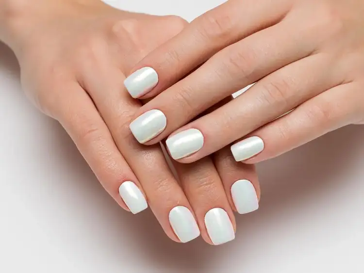 Dłonie z perłowymi paznokciami. Dowiedz się, jak nakładać pyłek na paznokcie, by uzyskać taki efekt.