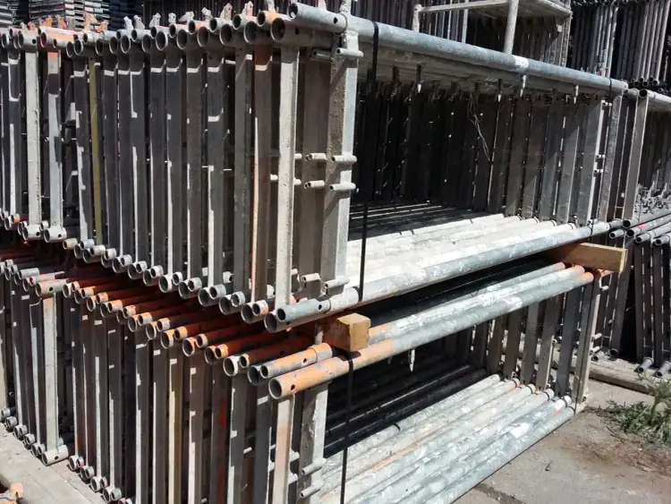 Stojaki rusztowań czekają na montaż. Zastanawiasz się, ile kosztuje rozstawienie rusztowania? Oto stosy elementów gotowych do pracy.