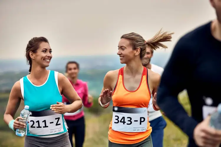 Uśmiechnięte biegaczki na trasie półmaratonu. Dobra forma i przygotowanie to klucz do sukcesu.
