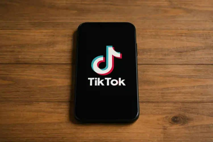 Smartfon z logo TikToka na czarnym ekranie. Chcesz wiedzieć, jak zainstalować TikToka? To proste!