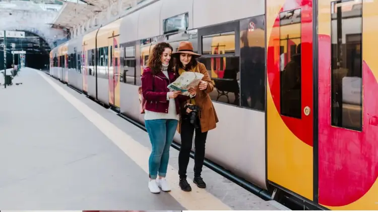 Dwie kobiety z mapą na dworcu, planują gdzie najszybciej nad morze z Poznania.