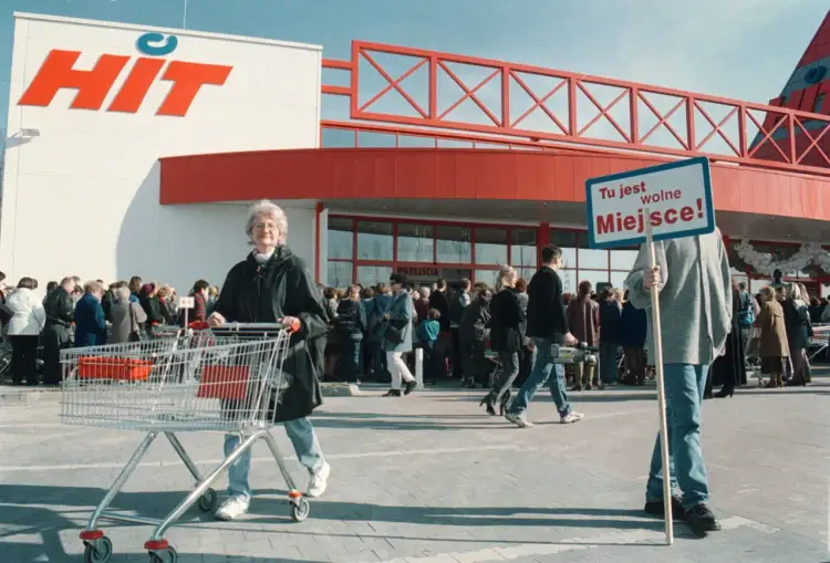 Klienci przed wejściem do sieci francuskich hipermarketów HIT. Jedna osoba trzyma tabliczkę "Tu jest wolne Miejsce!".
