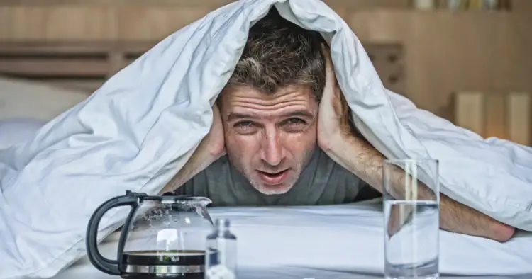 Następnego dnia rano, mężczyzna z przerażeniem w oczach chowa się pod kołdrą, obok niego stoi dzbanek kawy i szklanka wody.