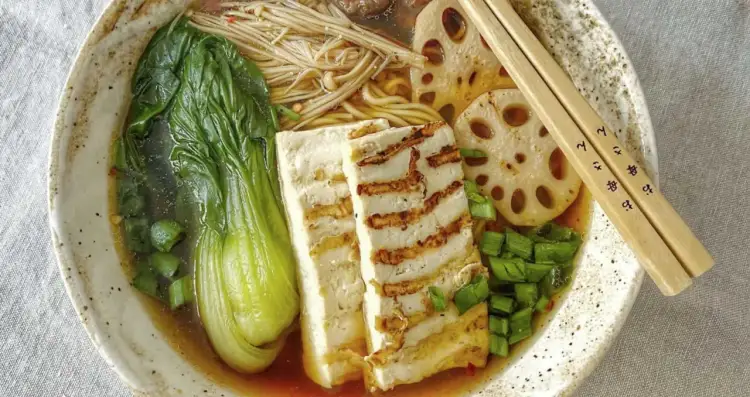 Aksamitny vege ramen z grillowanym tofu, pak choi, grzybami enoki i plasterkami lotosu. Idealny na chłodny wieczór.