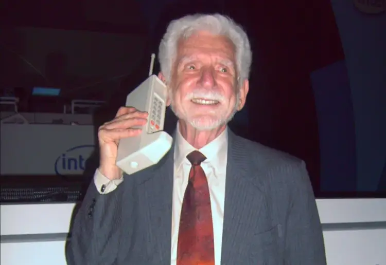 Martin Cooper, który wymyślił telefon komórkowy, prezentuje swój wynalazek.