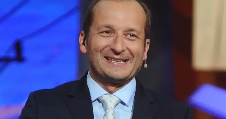 Uśmiechnięty Robert Górski z Kabaretu Moralnego Niepokoju w garniturze i jasnym krawacie.