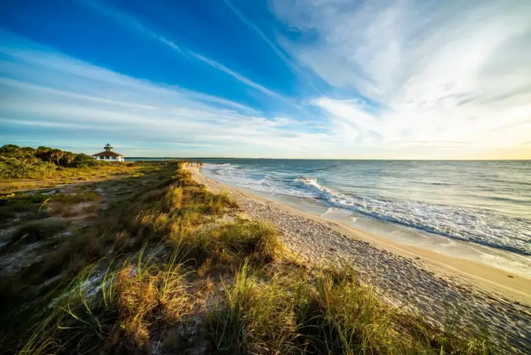 Spokojna plaża na Florydzie z latarnią morską w oddali. Czy na Florydzie jest bezpiecznie? Tak, to idealne miejsce na relaks.