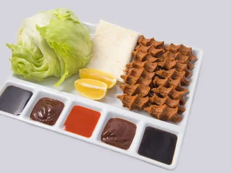 Talerz z sałatą, cytryną, tortillą i kilkoma sosami, w tym oryginalny turecki sos do kebaba.