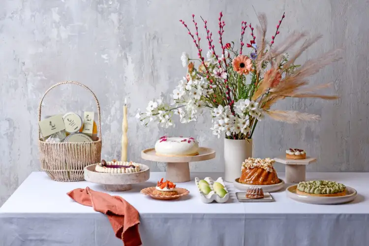 Stół pełen słodkości: torty, babeczki, koszyk z upominkami. Zastanawiasz się, ile kosztuje tort urodzinowy?