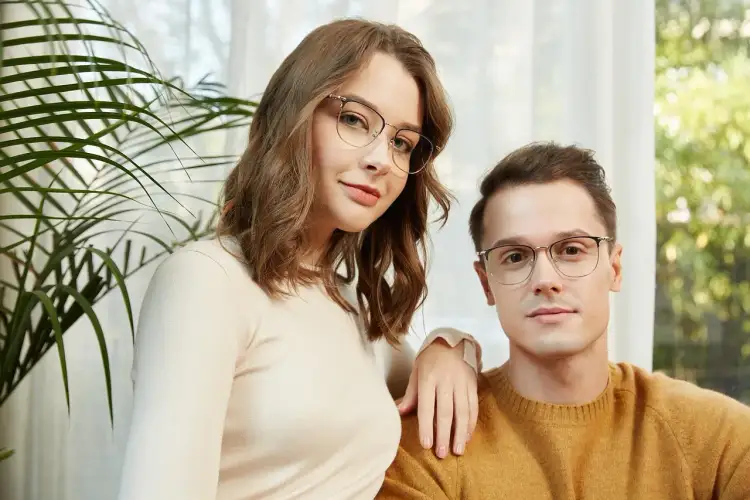 Para stylowych osób w okularach bez oprawek, ona w beżowym swetrze, on w musztardowym.