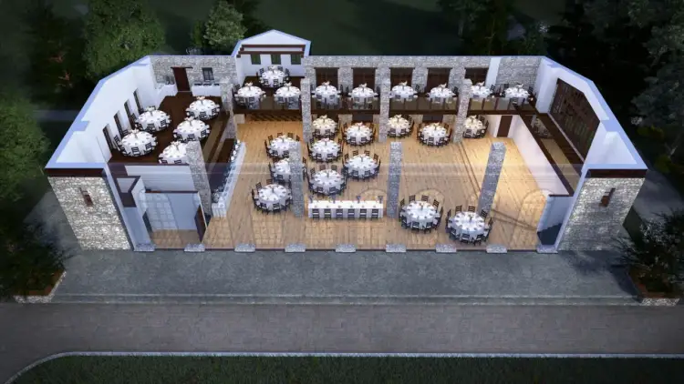 Elegancki dwór w Tomaszowicach gotowy na przyjęcie gości. Wnętrza z kamienia i drewna, udekorowane okrągłymi stołami z białymi obrusami, czekają na uroczystość.