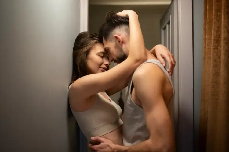 Para przytulająca się w intymnej chwili, sugerującej pozycje seksualne na stojąco.