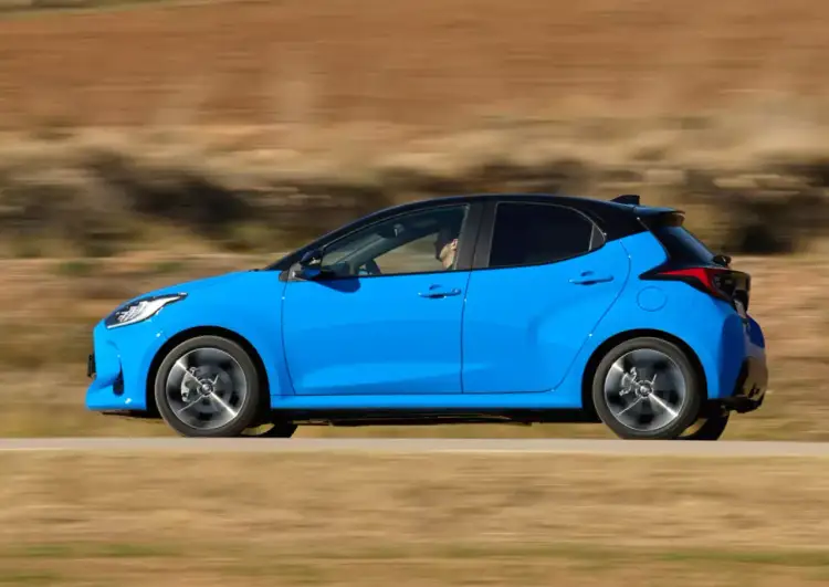 Błękitne, małe auto dla pań pędzi po drodze. Stylowe i zwinne, idealne do miasta.