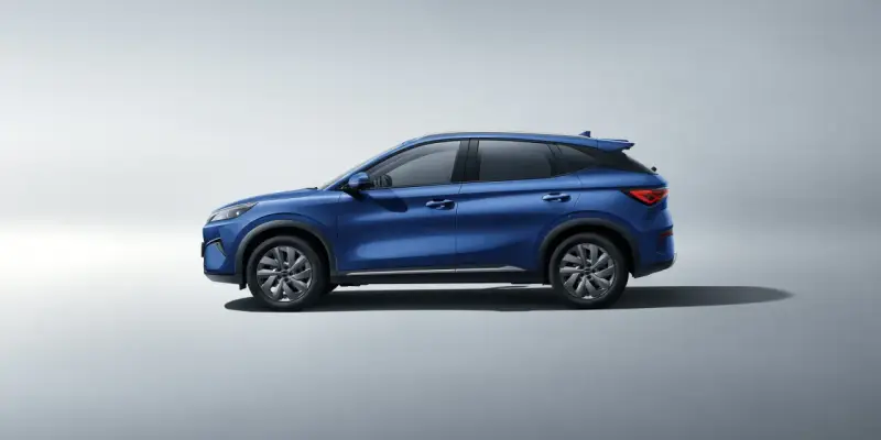 Niebieski SUV BYD Atto 3 Evo widziany z boku na jasnym tle.