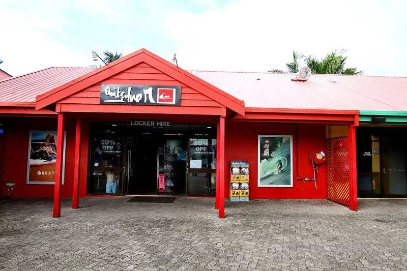 Sklep Quiksilver, znanej firmy odzieżowej dla surferów, z czerwonym logo i ofertą "Locker Hire".