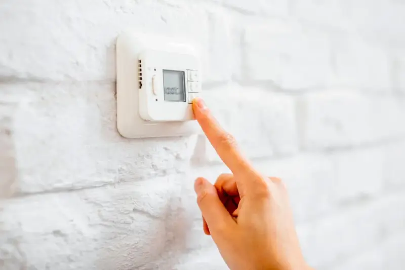 Ajustando el termostato para unos agradables grados calefaccion invierno.