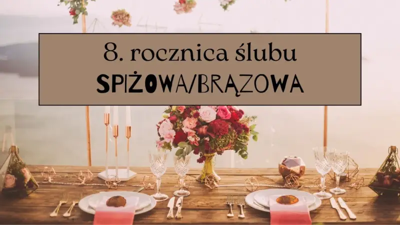 Elegancko nakryty stół na 8. rocznicę ślubu. Bukiet róż, kieliszki i świeczniki w odcieniach brązu i miedzi.