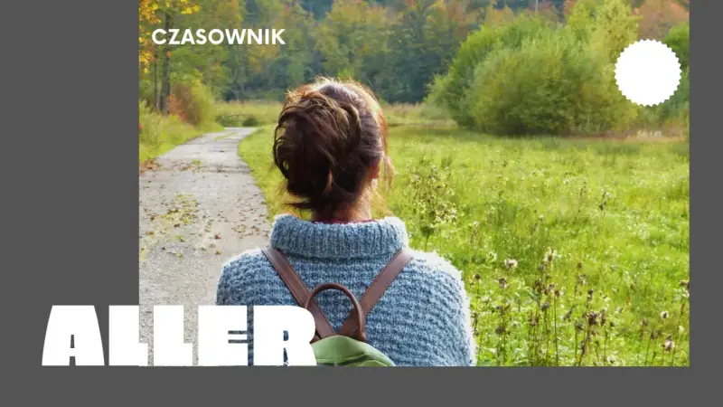 Osoby po francusku, spacerujące jesienną alejką wśród kolorowych drzew.