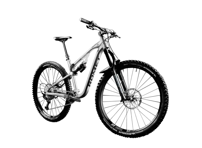 Srebrny rower górski full-suspension, model Dagger 2.0, z oponami Michelin Wild Enduro. Idealny do jazdy po trudnym terenie, czyli właśnie mtb co to.