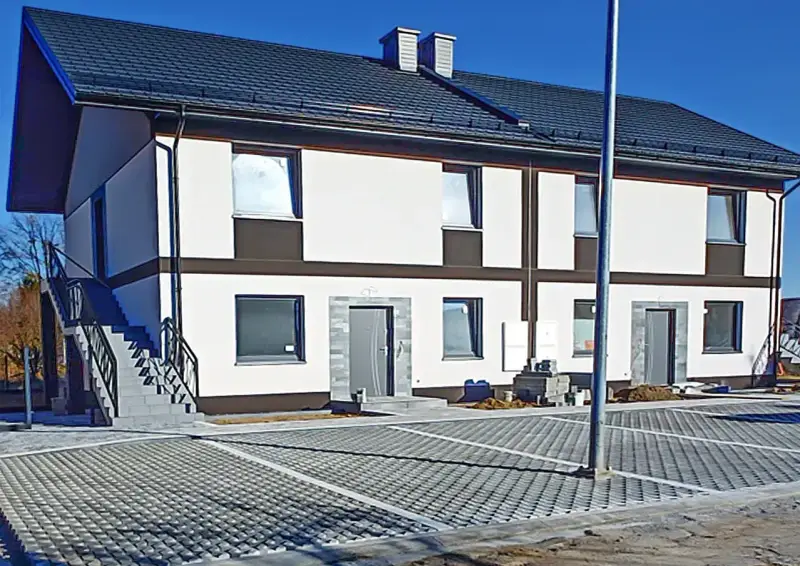 Nowy bliźniak w stanie deweloperskim, gotowy do wykończenia. Nowoczesna elewacja, parking z kostki brukowej.