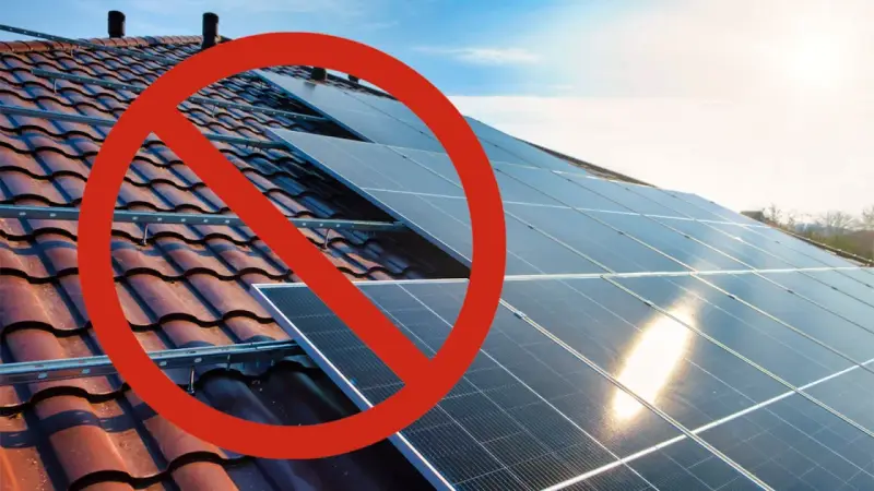Rött stopptecken över solpaneler på ett tak. Ett svea solar problem som hindrar installationen.