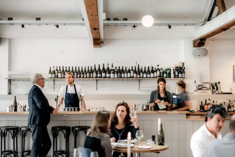 Un bar de restaurant moderne avec des employés derrière le comptoir, respectant les normes d'hygiène et de service.