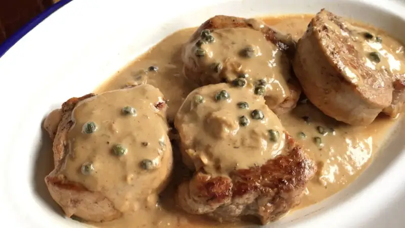 Cuatro medallones de solomillo a la pimienta en una cremosa salsa con granos de pimienta verde.