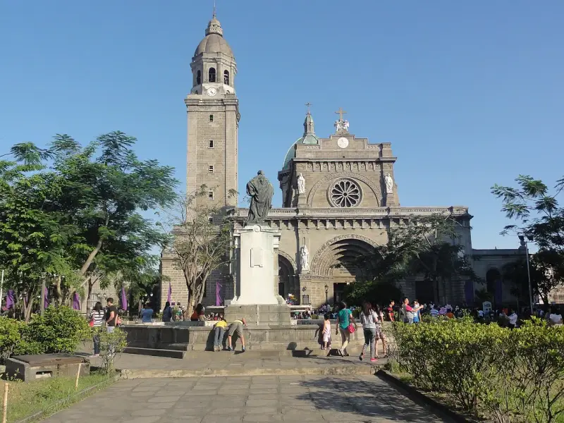 Manila Cathedral, symbol Filipiń religia. Ludzie spacerują przed monumentalną budowlą, podziwiając architekturę i atmosferę.