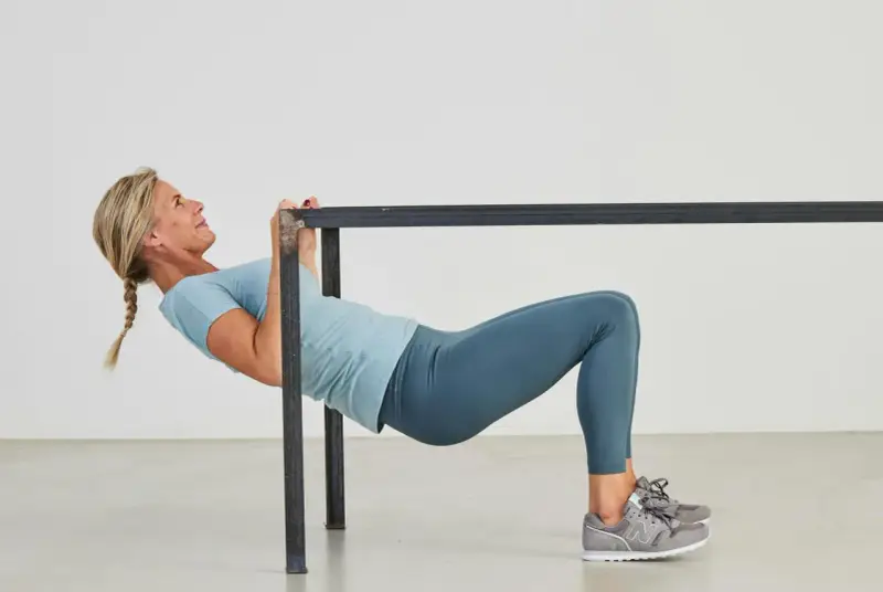 Kvinna utför overhead triceps extension vid en ställning.