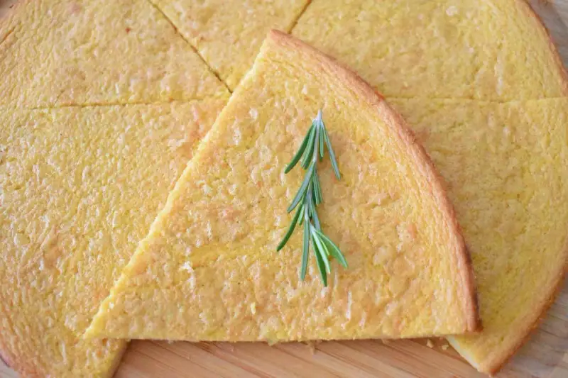 Schiacciata pokrojona w trójkąty, ozdobiona gałązką rozmarynu.