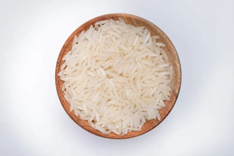 Miseczka z ryżem parboiled na białym tle.