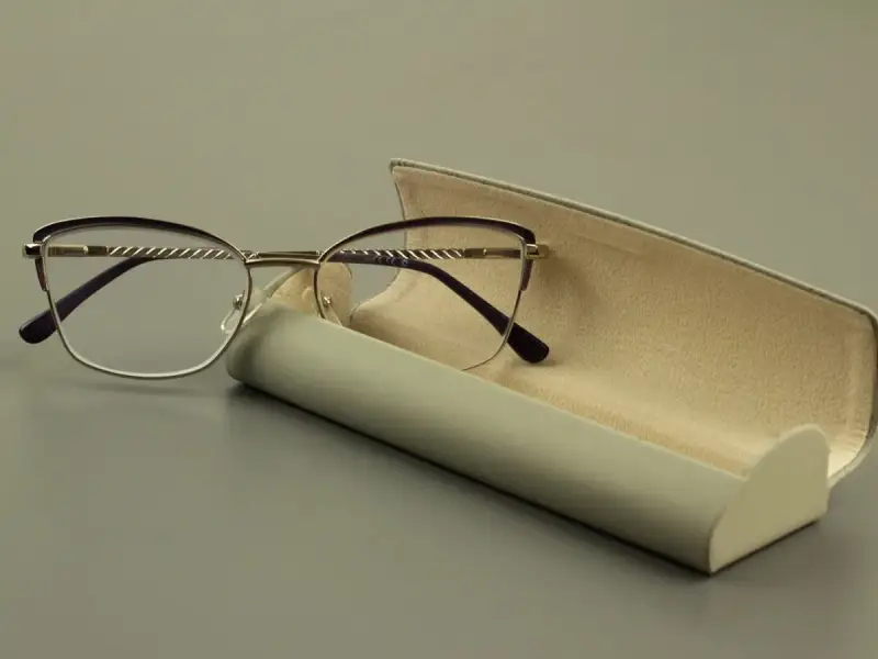 Eleganckie okulary z fioletowymi oprawkami i szkłami sferycznymi, obok futerału.