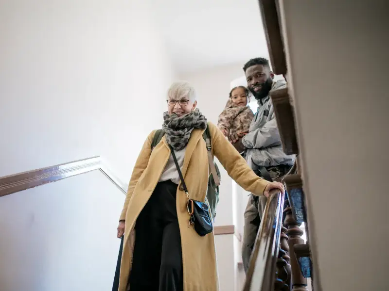 Glückliche Familie auf Treppe, die sich auf den Weg macht. Mit Ehe-Rechtsschutz ohne Wartezeit sind sie für alles gerüstet.