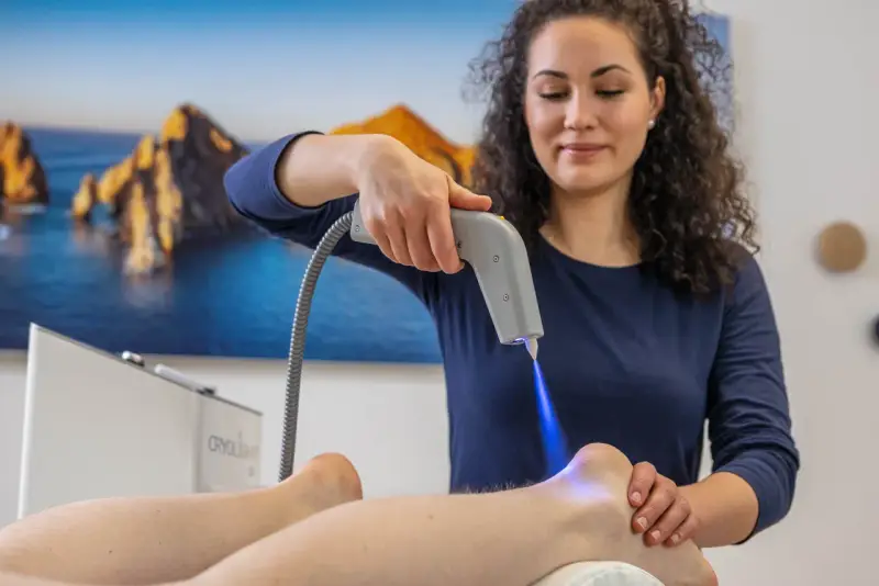 Therapeutin behandelt Fersensporn mit Kälteanwendung. Die Cryo-Therapie lindert Schmerzen, wie bei Liebscher & Bracht empfohlen.