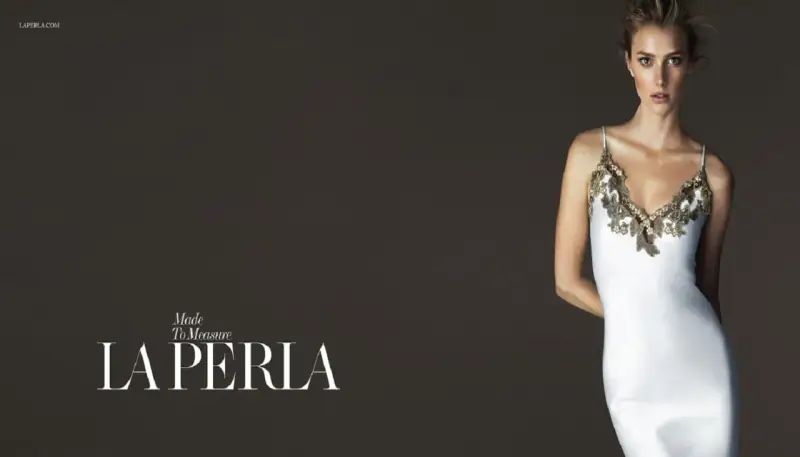 Model in a white slip dress with gold lace trim, with "LA PERLA" logo.