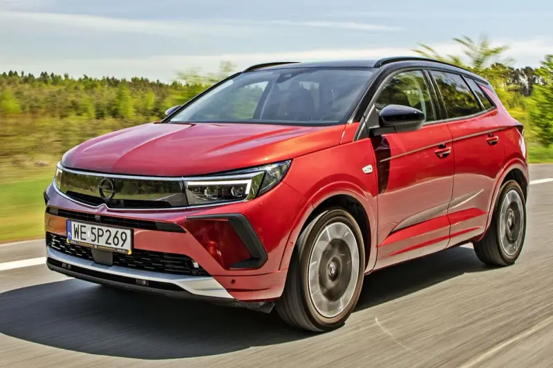 Czerwony Opel Grandland na drodze, idealny do sprawdzenia jego opel grandland cena.